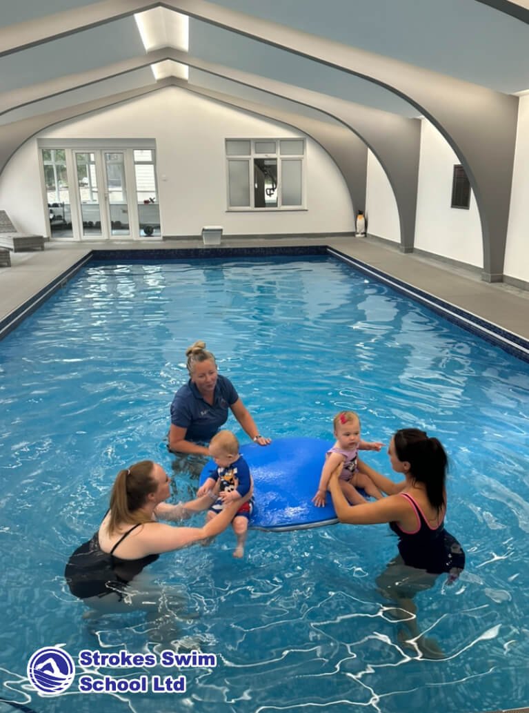 Baby class with blue float in the swimming pool