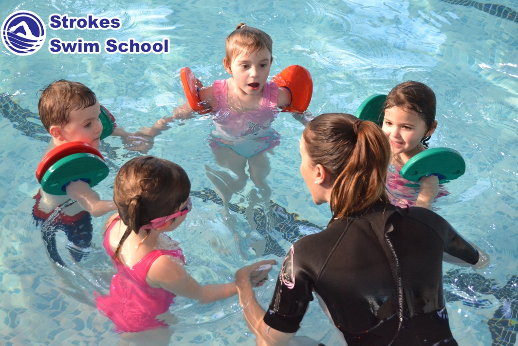 Group swimming lesson with instructor and children in the pool