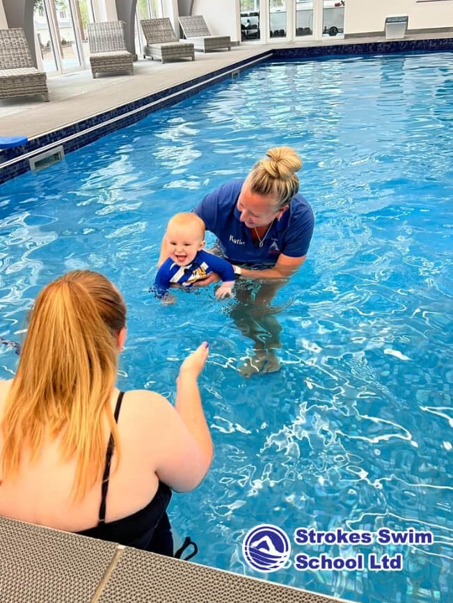 Instructor with baby during swimming lesson in pool