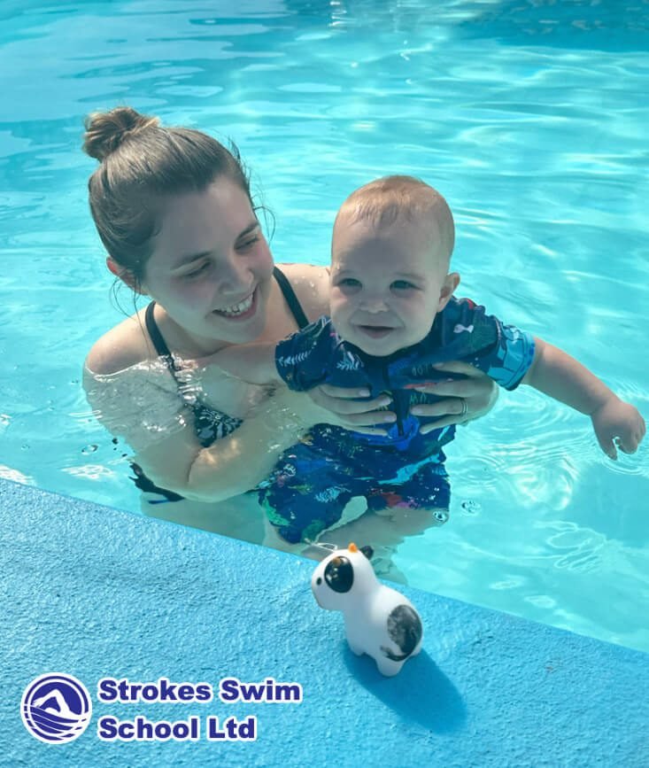 Swimming instructor teaching with kickboard