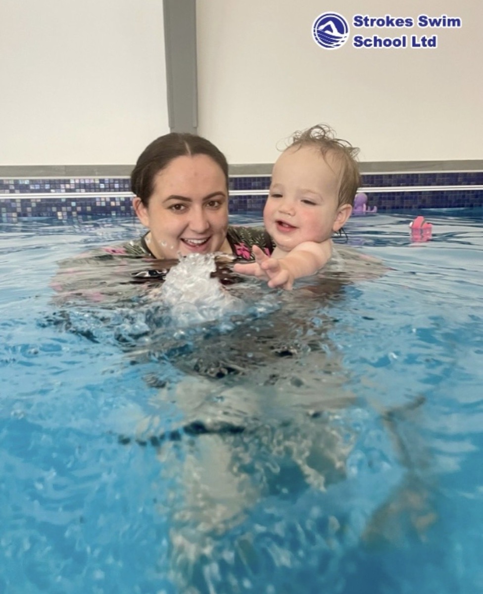 Toddler splashing during swimming lesson in Essex